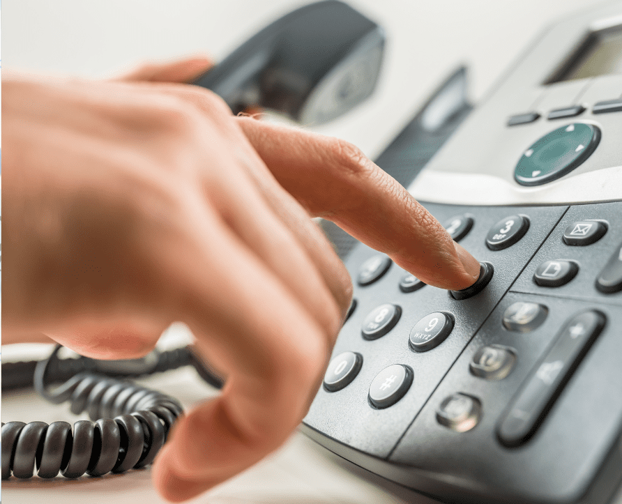 Image of a person dialing a number on the phone