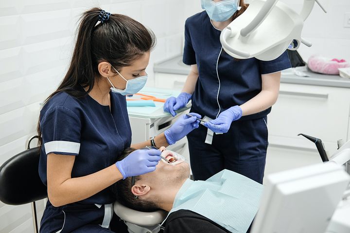 Dentist cleaning the teeth of her patient