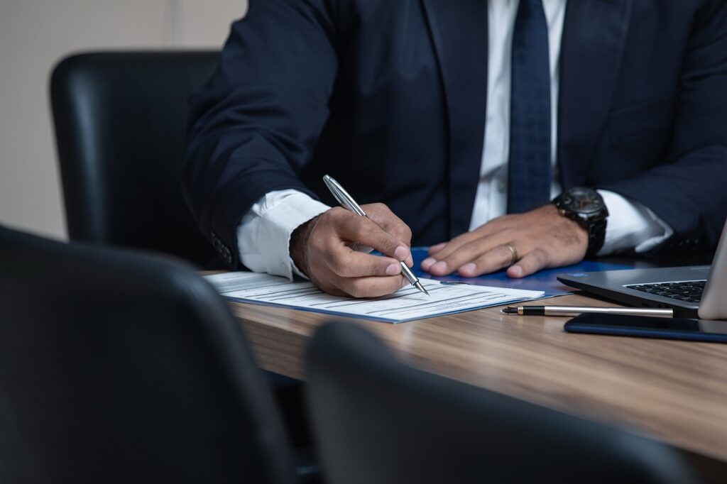 person writing something on the documents