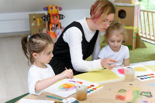 kids painting with their teacher