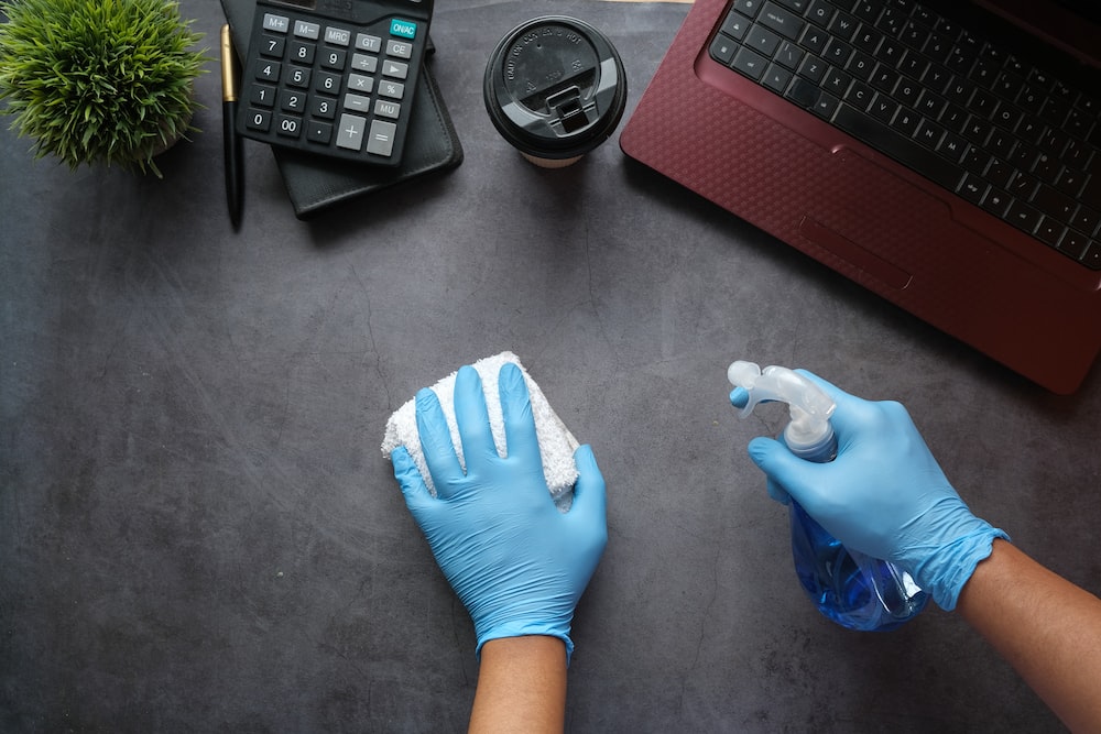 person cleaning the table with laptop