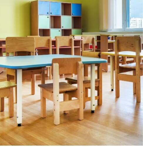 kids classroom with wooden table and chairs