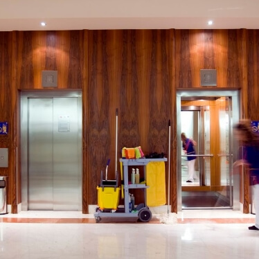 images of a janitor cleaning in front of the elevator