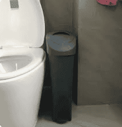 Commercial bathroom with toilet and trash bin for cleaning services.